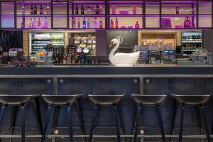 Bar stools with pink lighting and decorative swan