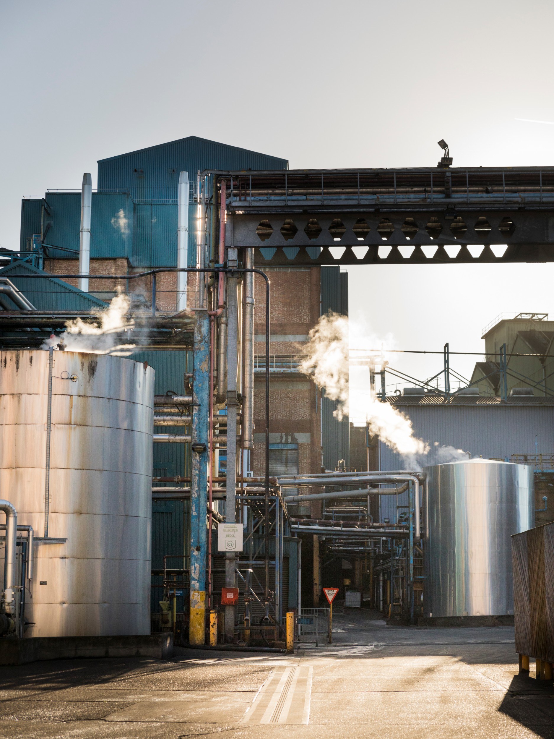Exterior of a building that looks like a factory, with chimneys and cylindrical structures