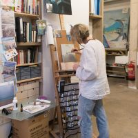 Artist in a studio painting at an easel