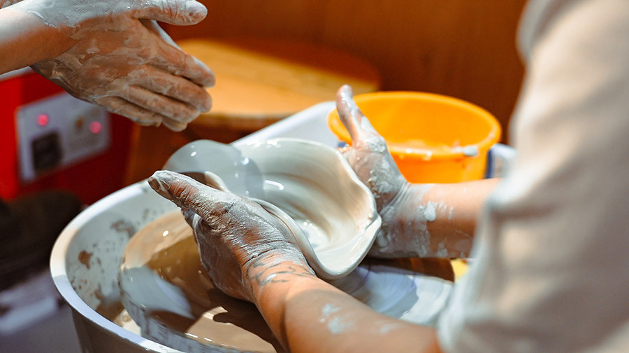 A person making pottery on a pottery wheel