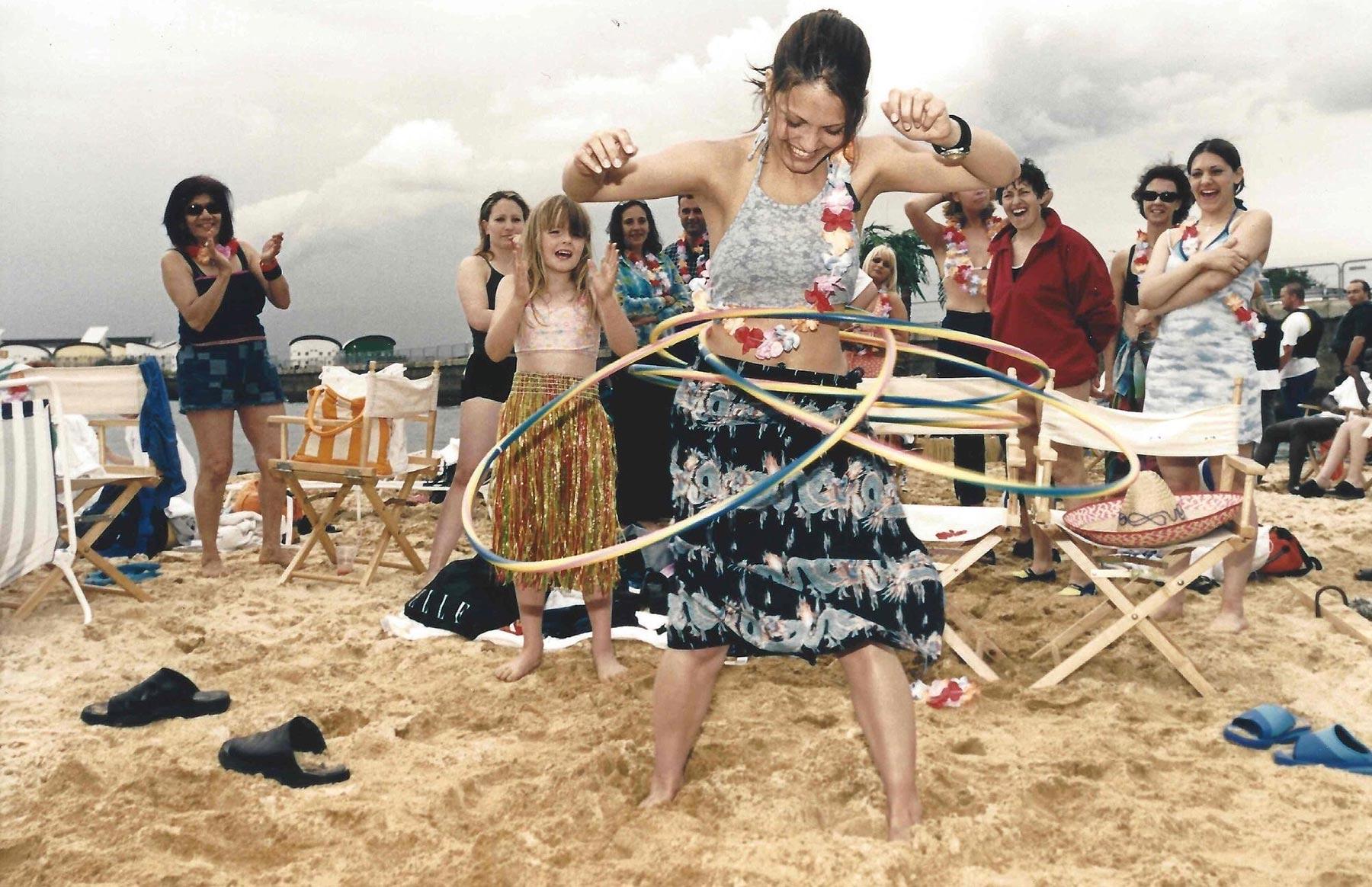 An old photo of young people hula-hooping on the Royal Docks beach