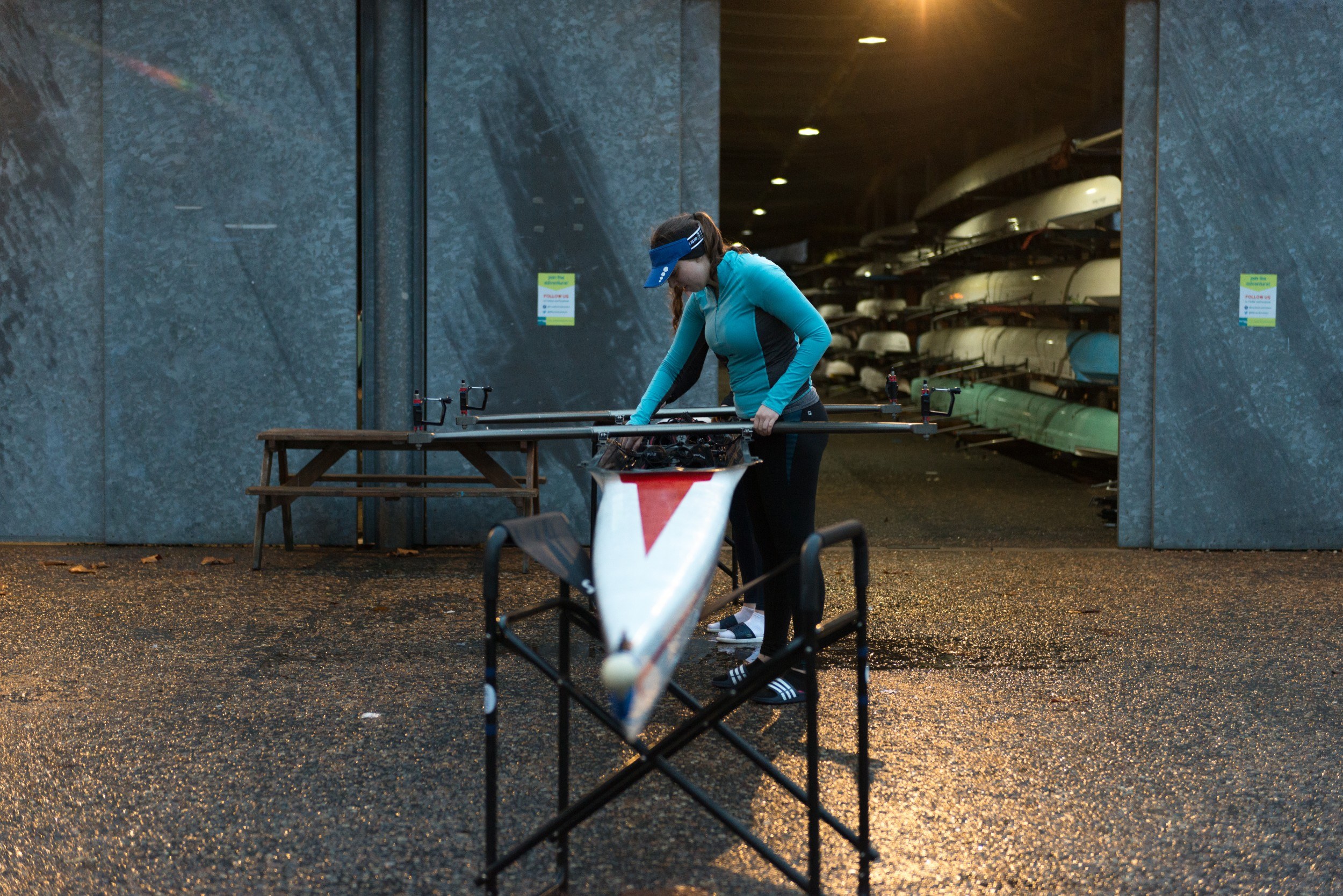 Woman with rowing boat outside boat shed