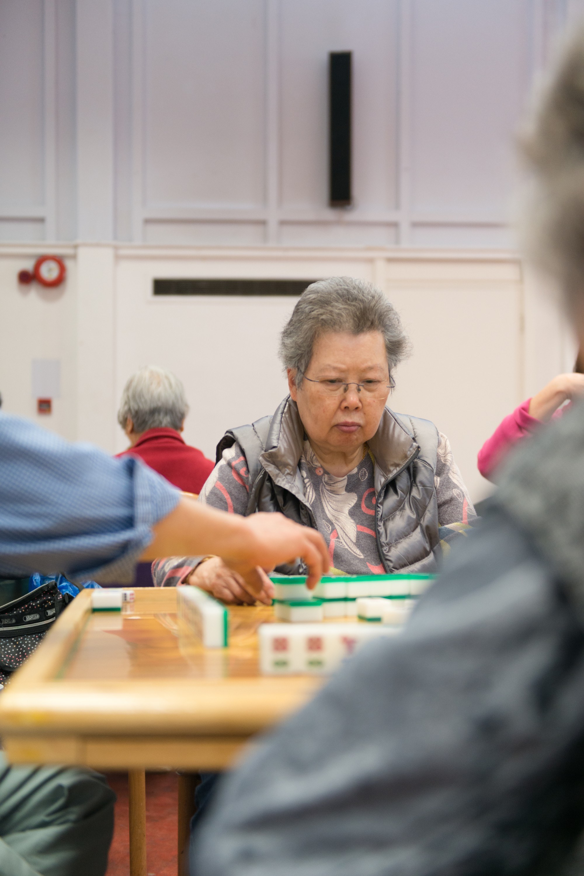 Woman playing tile-based game with look of concentration