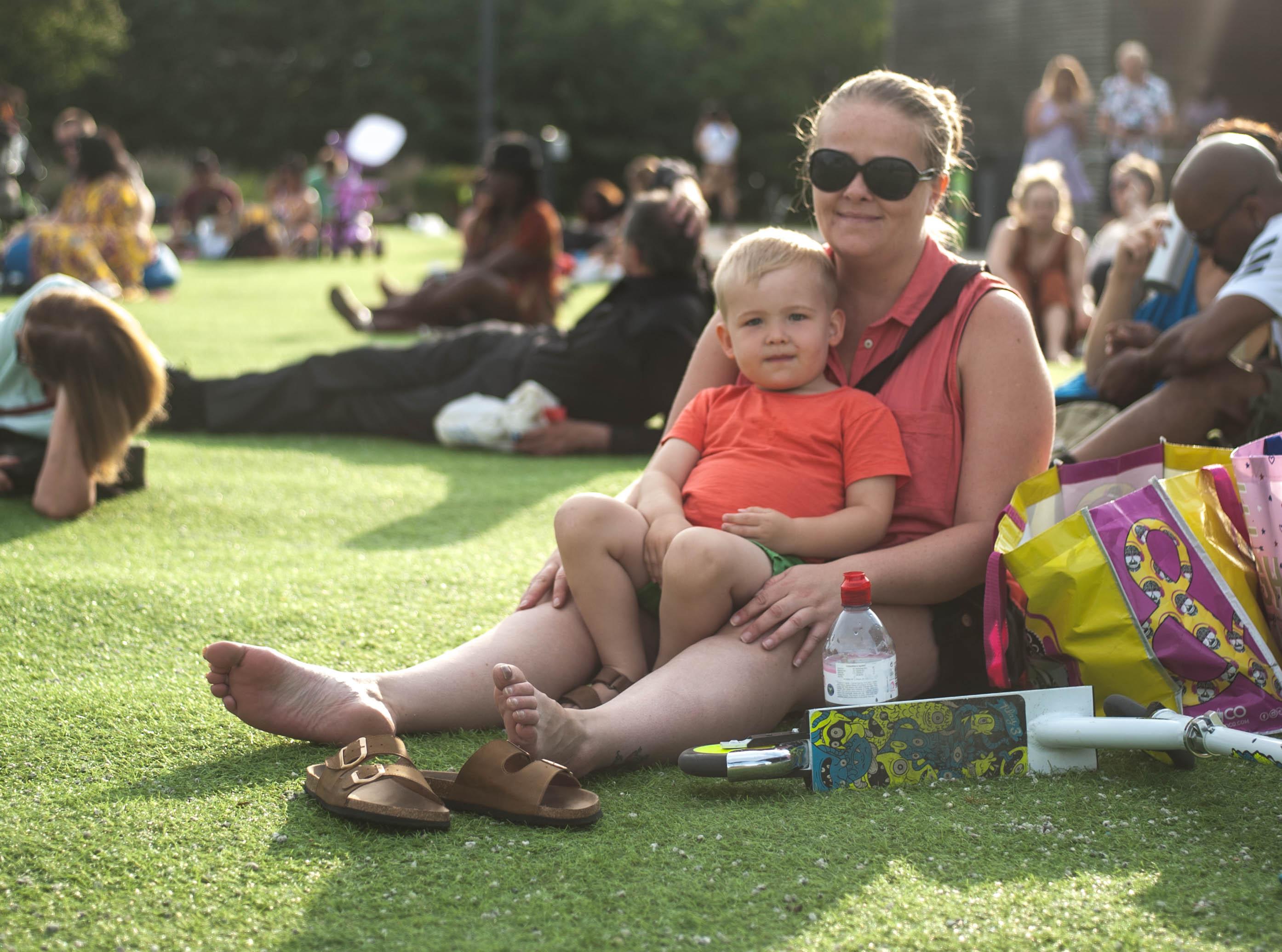A woman sat with child on the grass