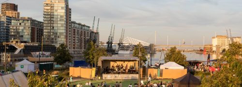 A crowd watching a band perform with the Emirates Cable Car overhead