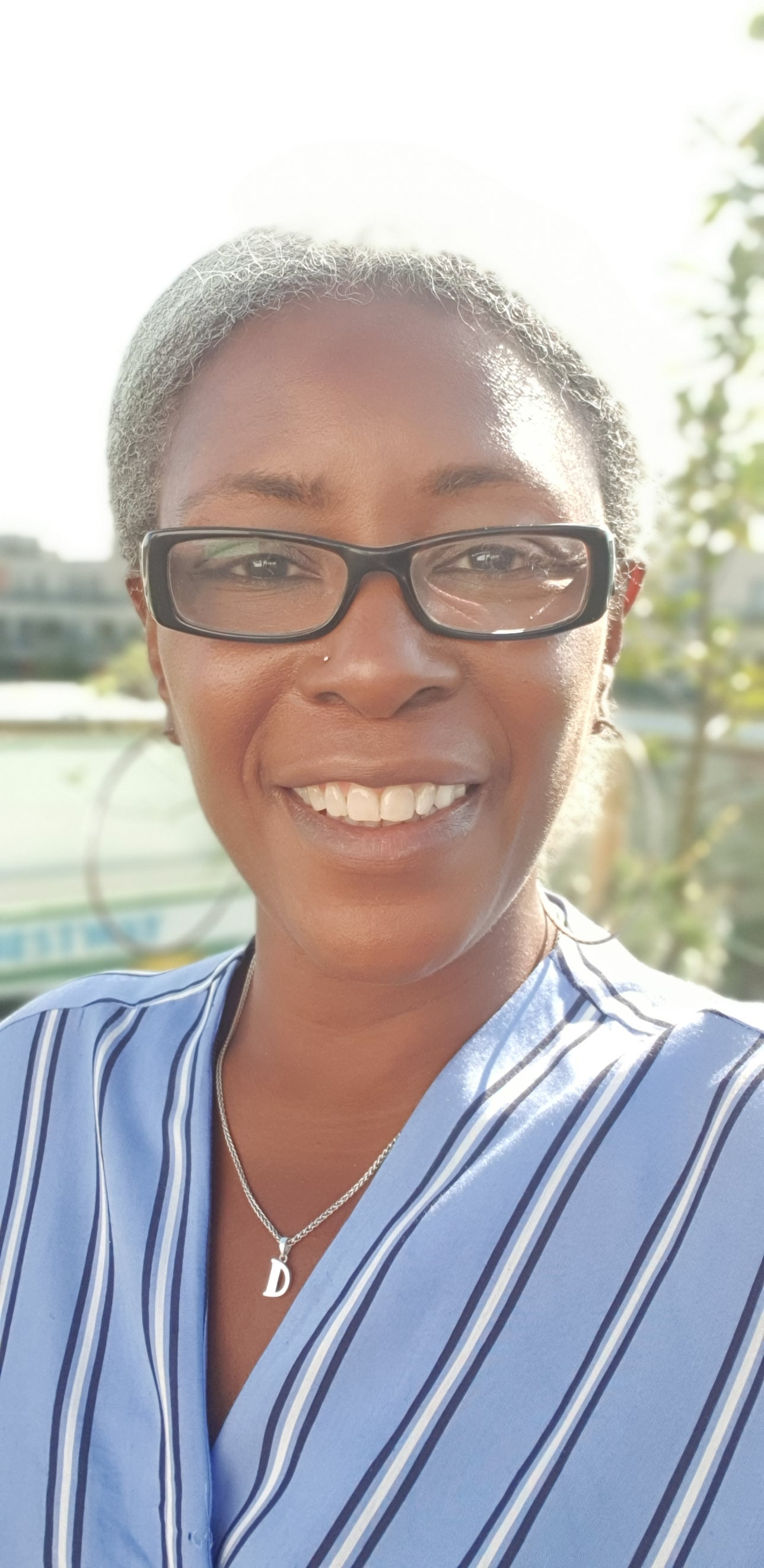 Delia Barker in a blue blouse and glasses