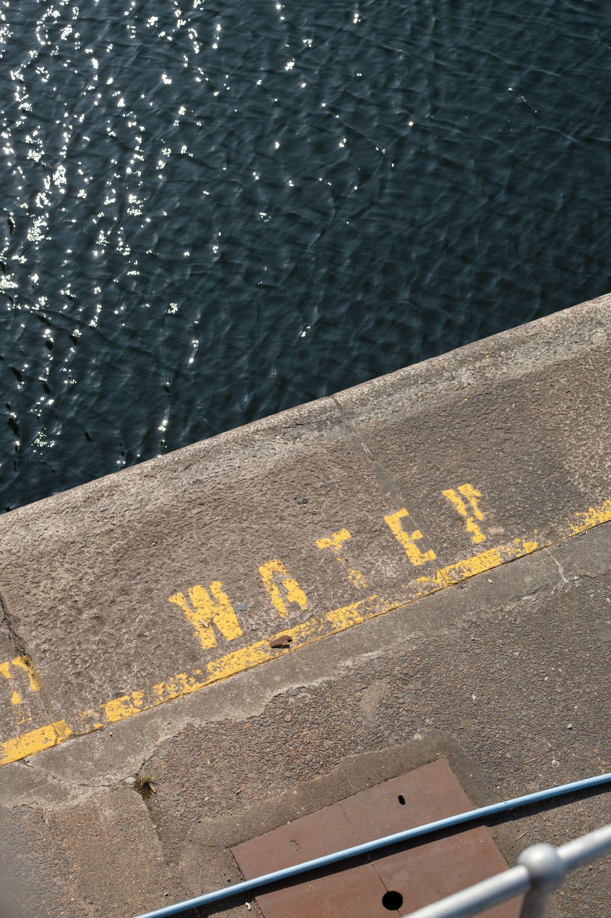 The dock water seen from above, with the word "water" painted on the edge