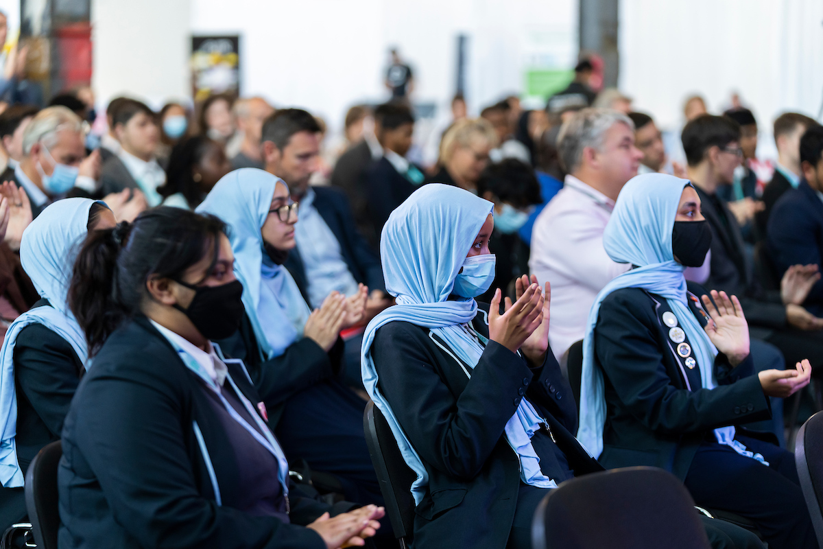 Schoolgirls in uniforms and masks clapping