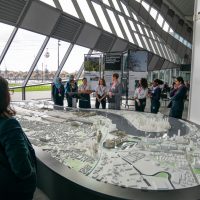 A crowd around a model of the Royal Docks at The Crystal